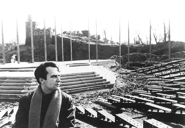 Joseph Papp, sitting in the bleachers as The Delacorte Theater in Central Park is being built.